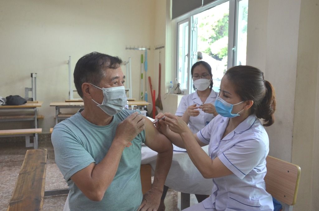 Ông Chu Văn Hải (khu 6, phường Hồng Hà, TP Hạ Long) được nhân viên y tế tiêm mũi 4 tại điểm tiêm Trường THCS Trần Quốc Toản (TP Hạ Long).